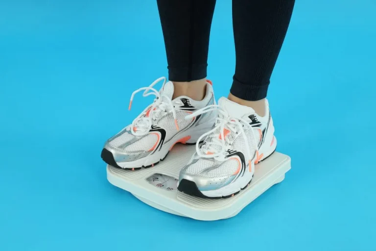 אשה עם נעלי ספורט על המשקל - איך לרדת במשקל