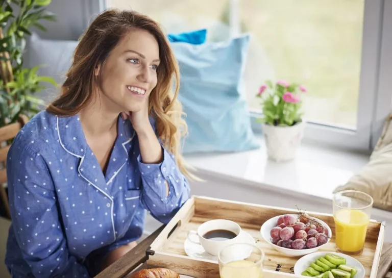 אשה שמחה אוכלת ארוחת בוקר בריאה - איך לרדת במשקל