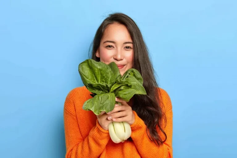 אשה מחזיקה ירק בריא - טיפים לירידה במשקל