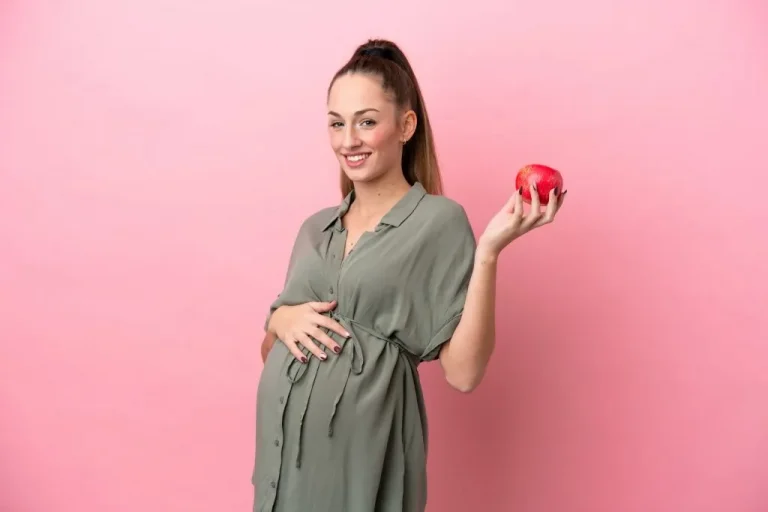 אשה בהריון אוכלת תפוח - תזונה עוזרת לבעיית נשירת שיער בהריון